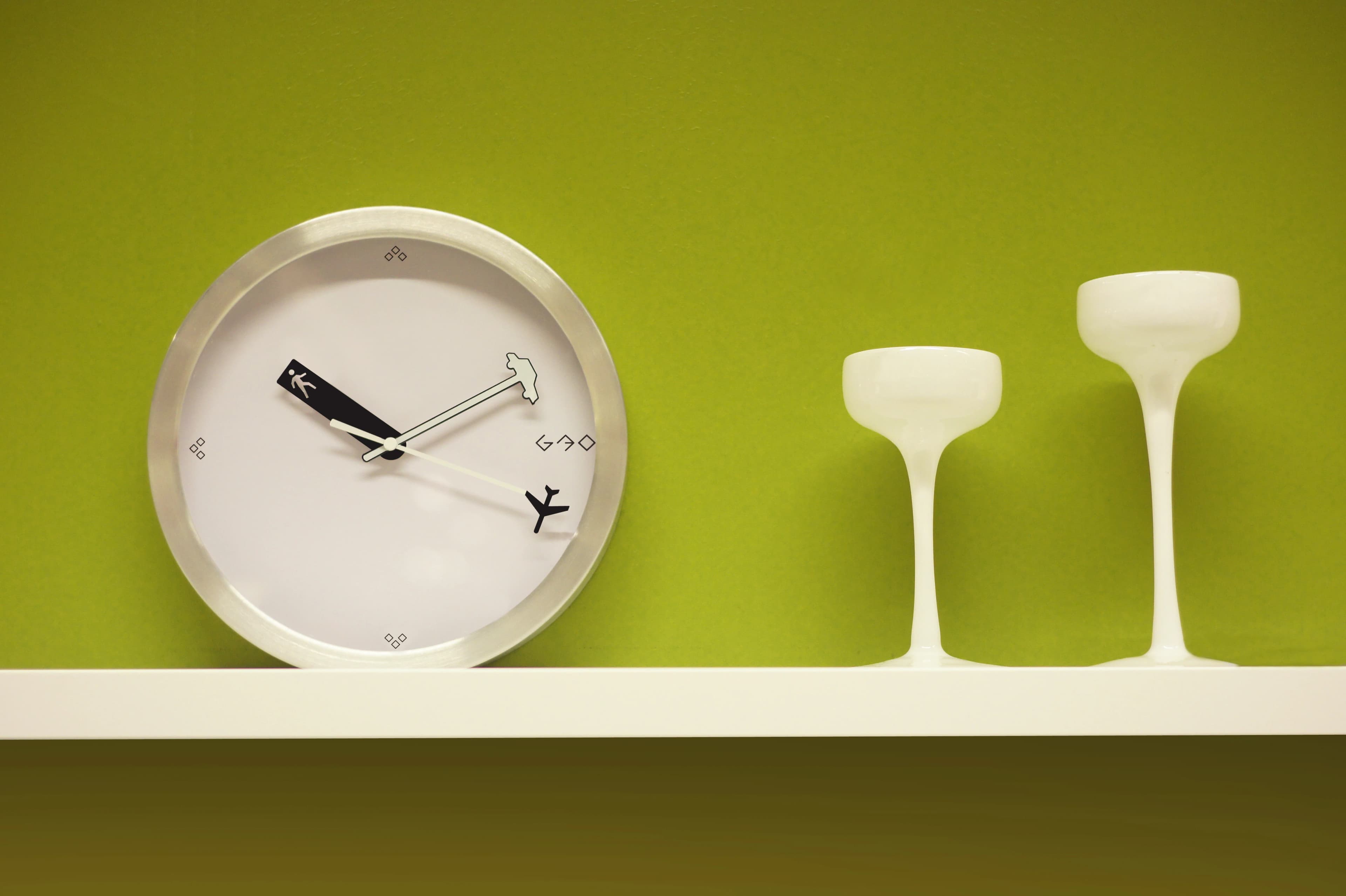 Day By Day clock on a green-wall shelf